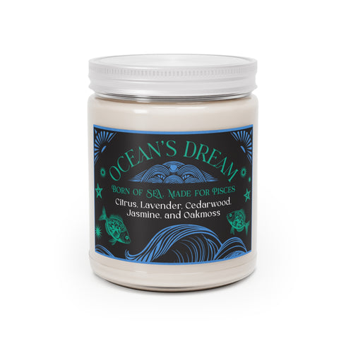 A 9 oz white soy candle in clear glass jar with blue and turquoise oceanic label featuring wave patterns and fish motifs, titled "Ocean's Dream" with a lit cotton wick.